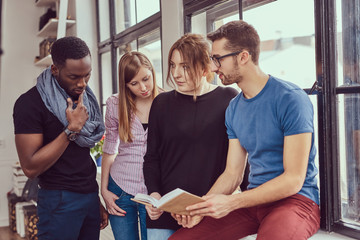 Group of young multiracial students working with books and phone