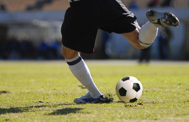 soccer player goalkeeper kick the ball during football match