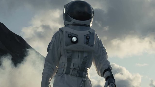 Medium Shot of the Astronaut Wearing Space Suit Walking and Exploring Gray Frozen Rocky Alien Planet. Shot on RED EPIC-W 8K Helium Cinema Camera.