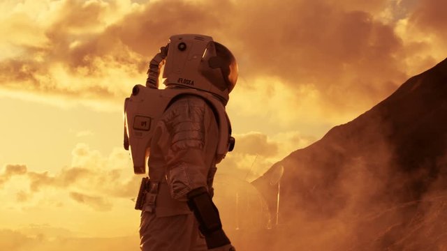 Handheld Side View Shot of the Astronaut Ascending Mountain on the Mars/ Red Planet. First Man on Alien Planet Overcoming Difficulties. Shot on RED EPIC-W 8K Helium Cinema Camera.