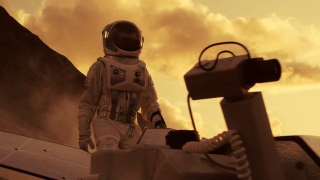 First Astronaut On the Mars, Checking His Rover and Exploring Site near His Base/ Research Center. Space Travel/ Exploration, Colonization. Shot on RED EPIC-W 8K Helium Cinema Camera.