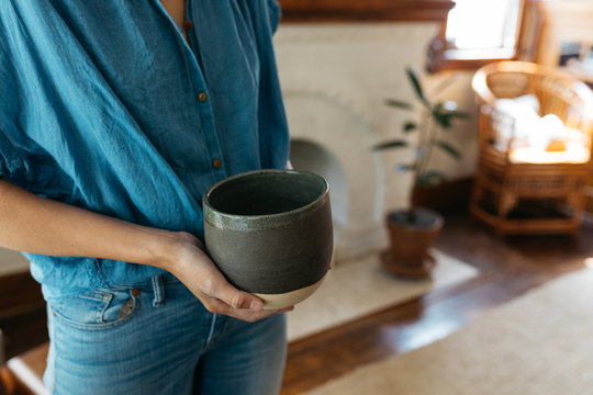 female small business owner ceramics maker shows final product of work