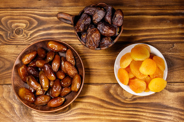 Dried apricots and dates fruit on wooden table. Top view