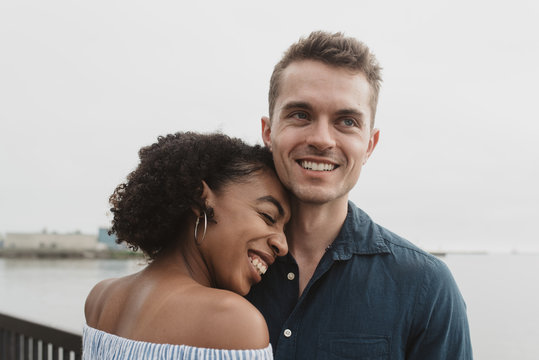 A young couple posing for portraits by the water