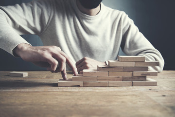 businessman making a pyramid  wooden cubes