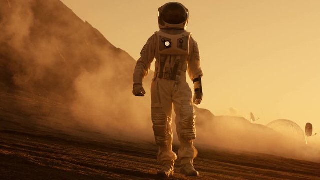 Proud Astronaut Confidently Walks on Mars Surface. Red Planet Covered in Gas and rock,  Overcoming Difficulties, Important Moment for the Human Race. Shot on RED EPIC-W 8K Helium Cinema Camera.
