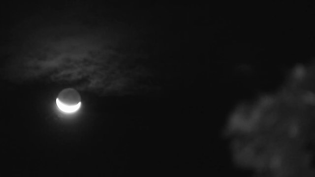 A blur to focus shot of a shining moon on monochromatic shot.
