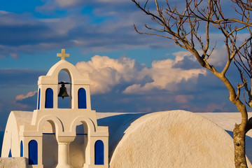 beautiful church bell and bare tree in winter oia greece