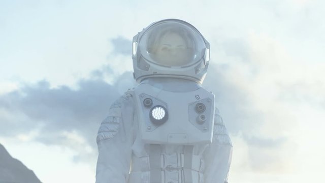 Medium Shot of Female Astronaut in the Space Suit Looking Around Frozen Alien Planet. Advanced Technologies, Space Travel, Colonization Concept. Shot on RED EPIC-W 8K Helium Cinema Camera.