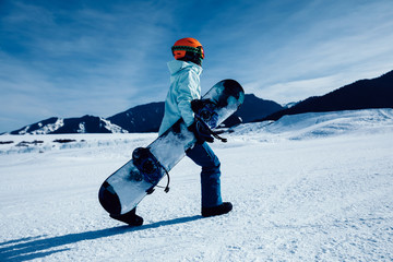 Fototapeta na wymiar one snowboarder with snowboard walking on winter mountain ski slope