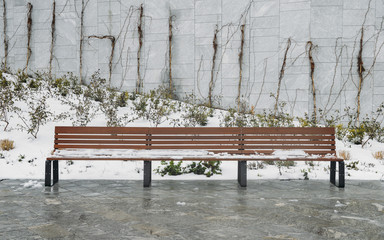 Wooden bench in the snow at park during winter.