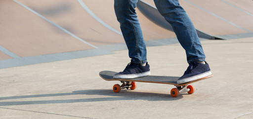 Obraz na płótnie Canvas skateboarder legs skateboarding on skatepark
