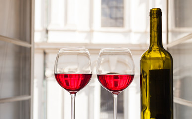 Pair of red wine glasses in a relaxing romantic European  setting. 