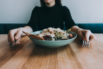 Flatlay salad with girl hands, knife and fork