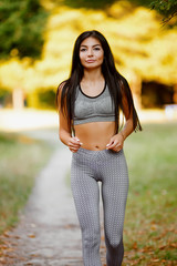 Young fitness woman running around in the park.