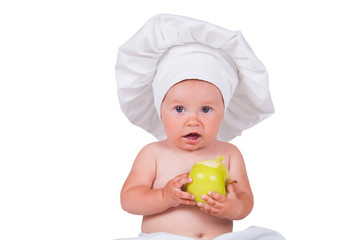 Cheerful little child with apples in hands in a chef suit on a white background.