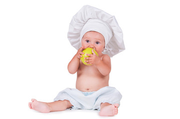 Cheerful little child with apples in hands in a chef suit on a white background.