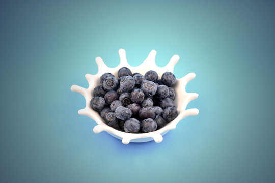 Blueberries stock images. Blueberries on a blue background. Blueberries in a white bowl