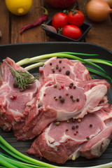 Ingredients for cooking rib eye roast beef steak on black iron grilling pan. Wooden rustic background. Top view, horizontal composition