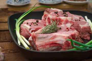 Ingredients for cooking rib eye roast beef steak on black iron grilling pan. Wooden rustic background. Top view, horizontal composition
