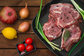 Ingredients for cooking rib eye roast beef steak on black iron grilling pan. Wooden rustic background. Top view, horizontal composition