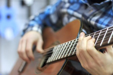 The guy plays a classical guitar in a music store, a musical mood, classical music.