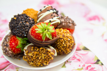 Strawberries dipped in chocolate with nuts on a table. Close up