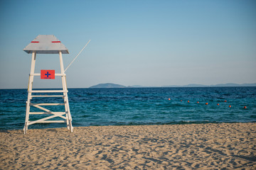 White lifeguard tower neartranquil water with copy space