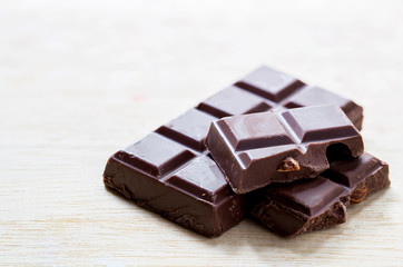 split bar of dark chocolate on wooden table