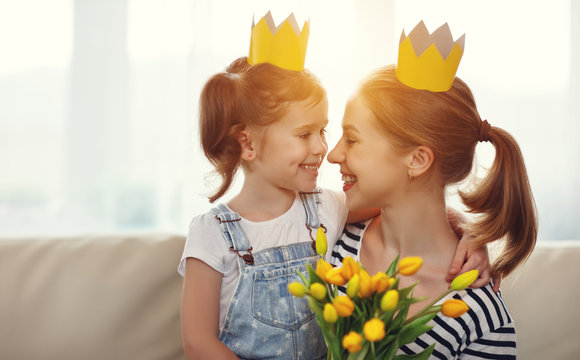 Happy Mother's Day! Mother And Child Daughter In Crowns And With Flowers .