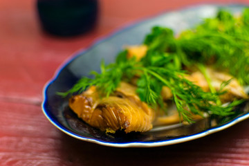 Hot smoked fish in a plate on a Wooden background color 