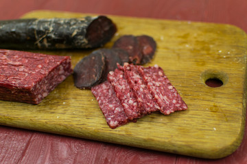 Smoked sausages are cut on a cutting board.