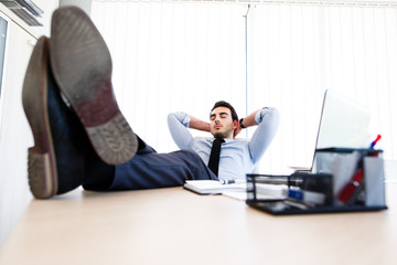 Young lazy businessman sleeps at office