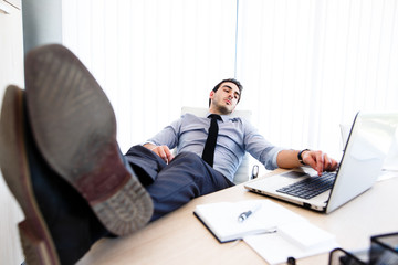 Lazy businessman put his legs on the desk