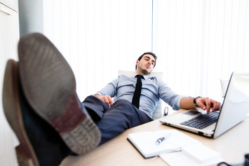 Lazy businessman put his legs on desk