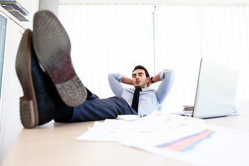 Young lazy businessman sleeps at office