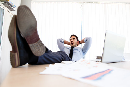 Young lazy businessman sleeps at office