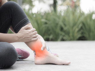 Woman suffering from an ankle injury while exercising.  Running sport injury concept.