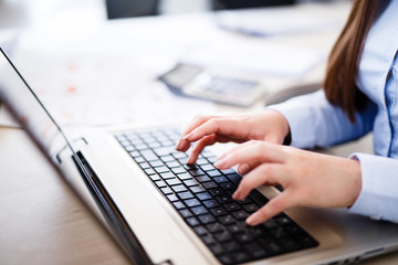Young female IT engineer typing on laptop