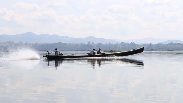 INLE LAKE, MYANMAR - JANUARY 14, 2016: Inle Lake Boat with unidentified people crossing the lake. Myanmar popular travel destination