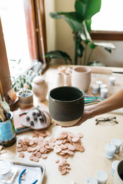 female small business owner ceramics maker shows final product of work