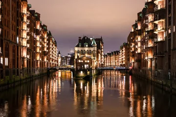 Hamburg Speicherstadt at night, Wasserschloss, buildings with reflection in water © Sebastian Ga