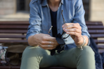 Woman cleaning lens of glasses