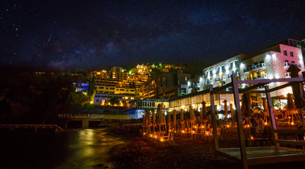 Fototapeta na wymiar View on illuminated coastline and old town at night in Budva, Montenegro