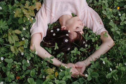From above view on attractive woman taking nap in strawberry blossom
