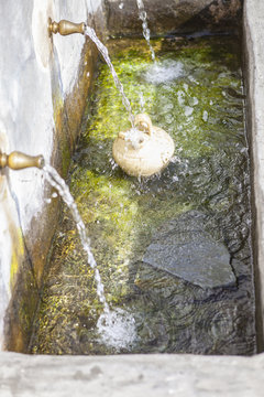 A botijo is filled with fresh water at public fountain at Alpujarras, Spain