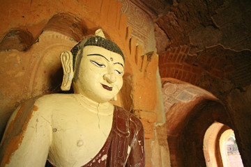 A giant statue of the Buddha sits calmly in the cool air inside a temple in Bagan, Burma