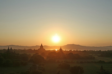 The golden sun sinks towards the Irrawaddy River and the distant mountains in Myanmar