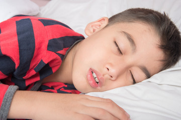 Little boy sleeping with white blanket cover his body