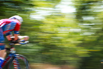 Motion blurred racing cyclist in red white and  blue